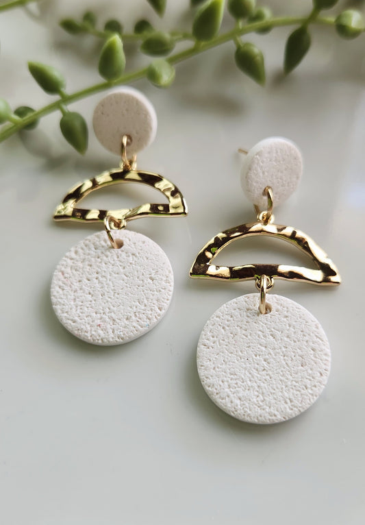 Handmade polymer clay earrings! White textured clay creates these dangles desinged with a small clay circle followed with an allow brass half circle connector and a large clay circle to finish earring. Lightweight, matte and approximately 2" long.