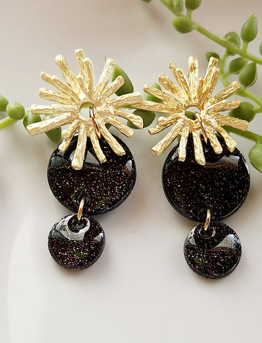 Handmade polymer clay earrings! Lightweight show-stopper earring design! The stunning earring design includes an alloy gold plated floral stud and two black shimmery polymer clay circles. Perfect for any occasion! Meant to stand out! Lightweight, with resin for a glossy look, and approximately 2" long.