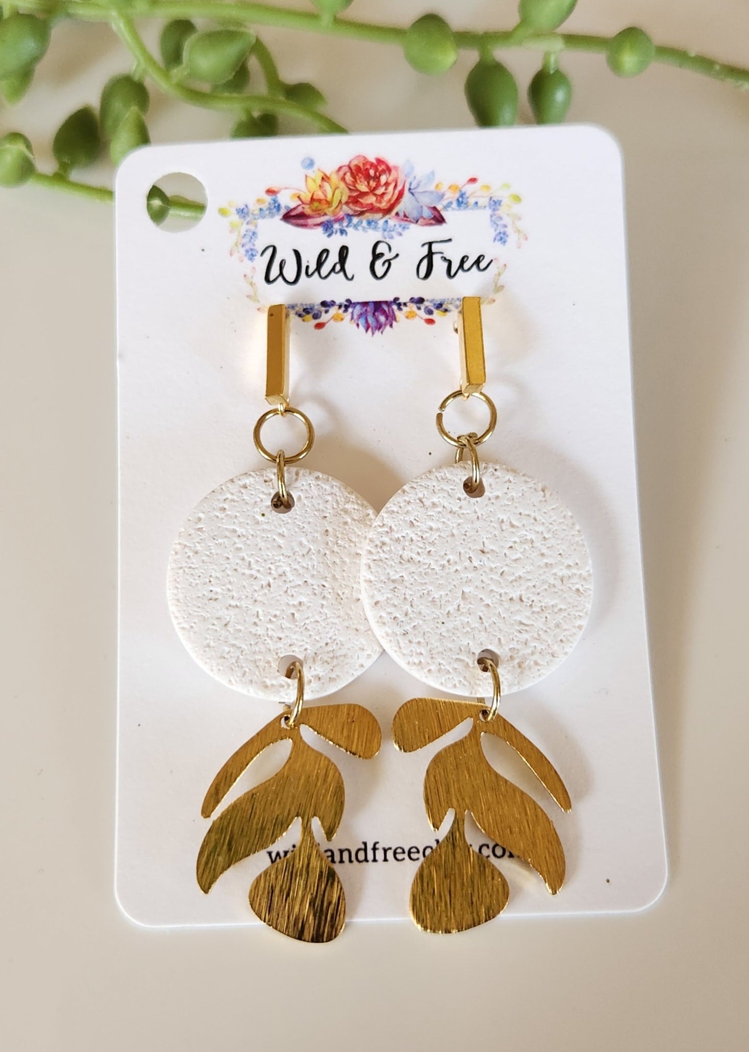 Handmade polymer clay earrings! This beutiful design is made out of white textued clay with a circle shape. There is a beautiful brass gold vine dangle giving it a unique design. A gold plated thin rectangle stud completes this look. Lightweight, matte and approximately 2" long.