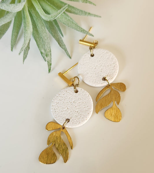 Handmade polymer clay earrings! This beutiful design is made out of white textued clay with a circle shape. There is a beautiful brass gold vine dangle giving it a unique design. A gold plated thin rectangle stud completes this look. Lightweight, matte and approximately 2" long.