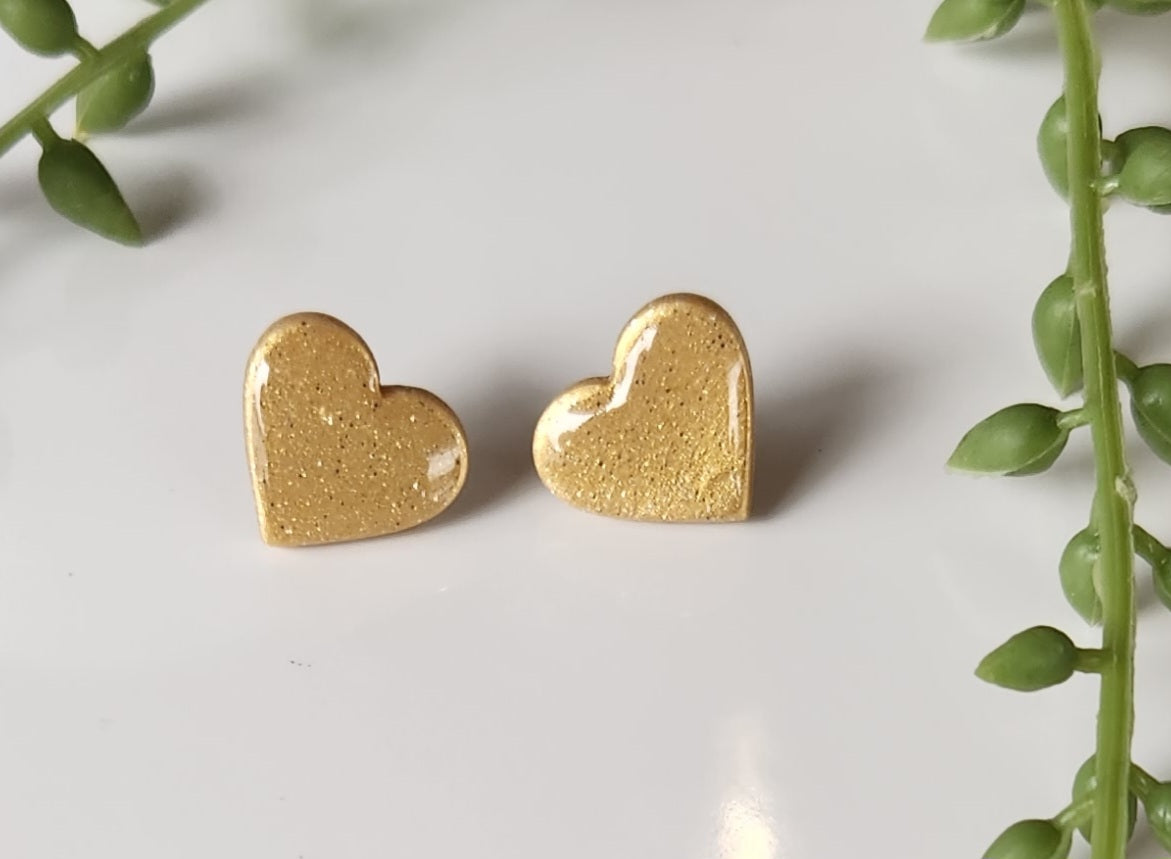 Handmade polymer clay heart earrings! Perfect shade of shimmer gold form these heart shape polymer clay earrings. Lightweight and with resin for a glossy look. Approximately .5" long.