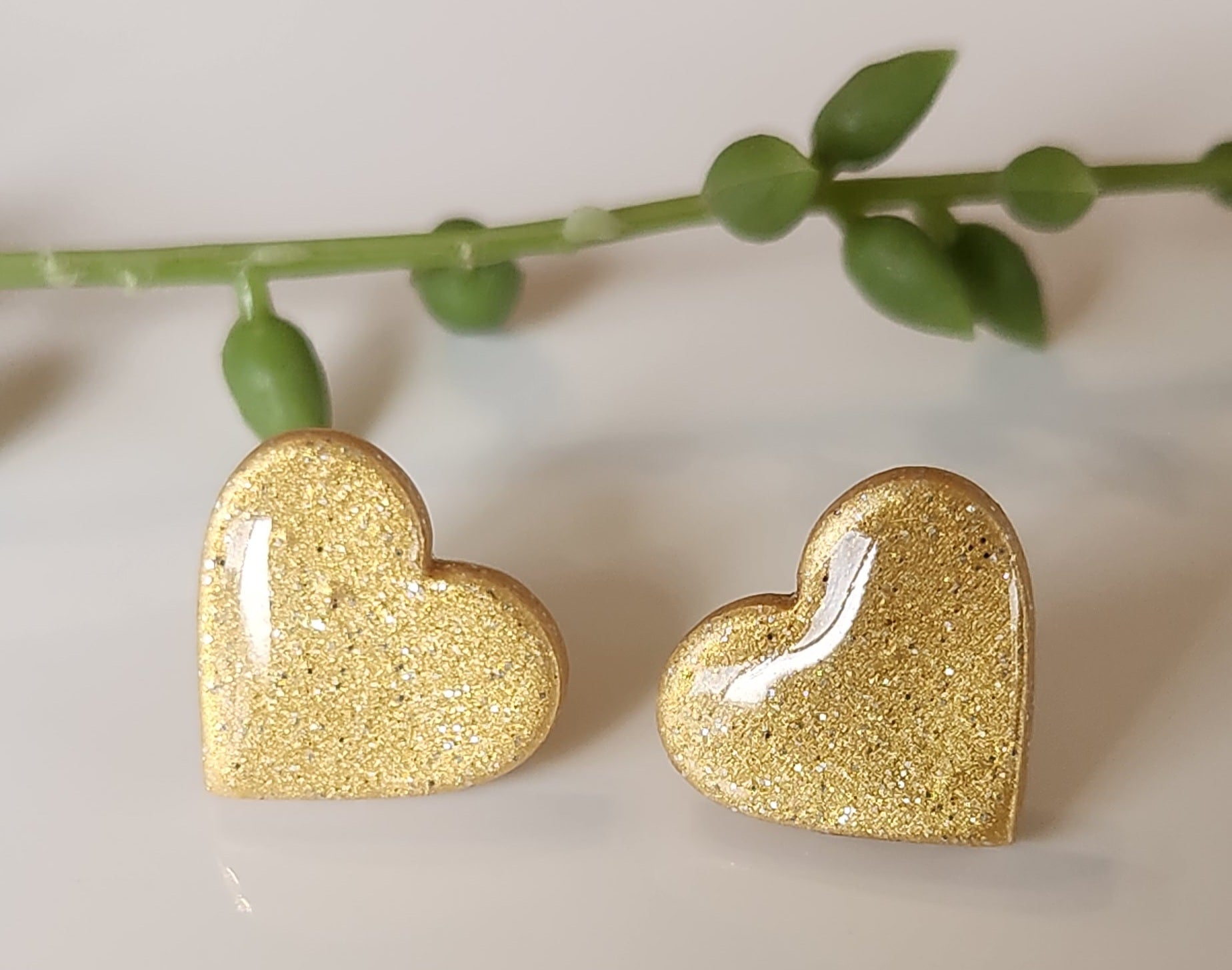 Handmade polymer clay heart earrings! Perfect shade of shimmer gold form these heart shape polymer clay earrings. Lightweight and with resin for a glossy look. Approximately .5" long.