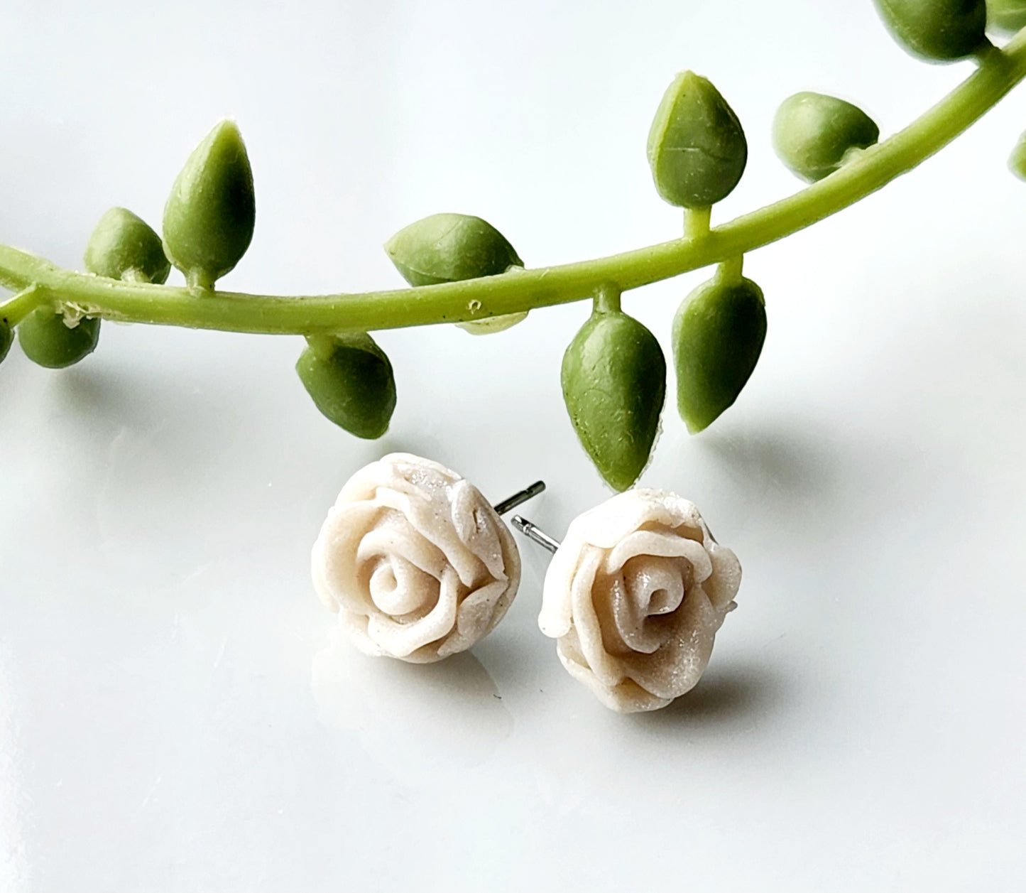 Handmade polymer clay earrings! Pefect sized studs of peal clay color designed as a rose. Lightweight and approximately .5" long.