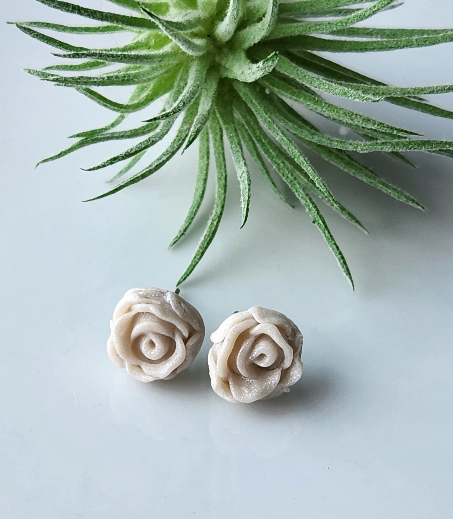 Handmade polymer clay earrings! Pefect sized studs of peal clay color designed as a rose. Lightweight and approximately .5" long.