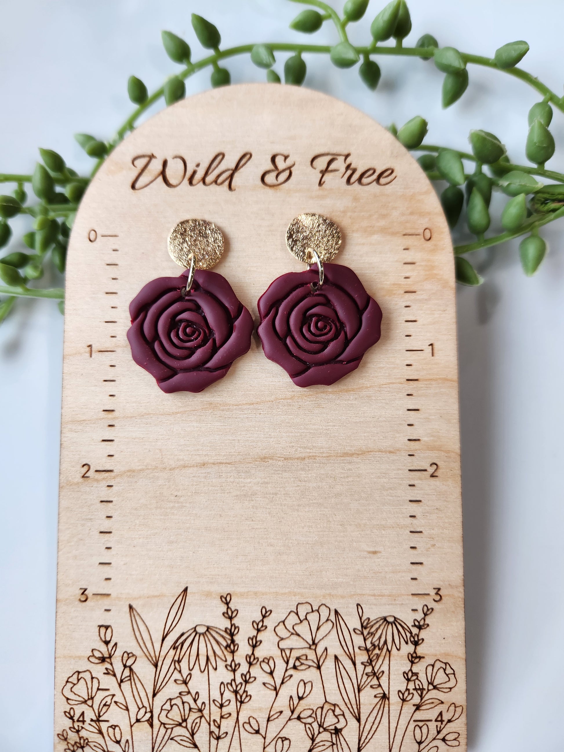 Handmade polymer clay earrings! These beautiful clay dangles are of a rose design with two different colors, red and red wine. They are matte with a shimmery gold-plated circle stud. Lightweight and approximately 1.5" long.