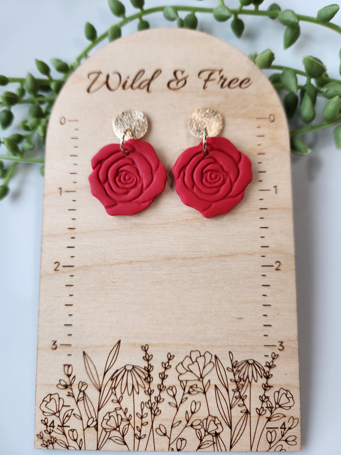 Handmade polymer clay earrings! These beautiful clay dangles are of a rose design with two different colors, red and red wine. They are matte with a shimmery gold-plated circle stud. Lightweight and approximately 1.5" long.