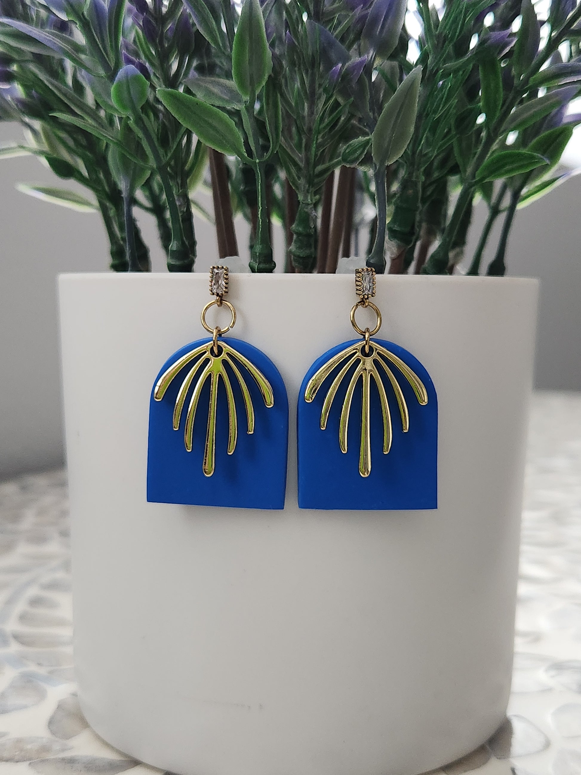 Handmade rich blue polymer clay earrings! This bright blue color is my favorite! These dangle earrings are of a dome shape with a gold-plated charm consisting of 7 lines facing down. A sterling silver needle zircon earring post completes this earring design. They are sure to stand out, lightweight, and approximately 2" long.