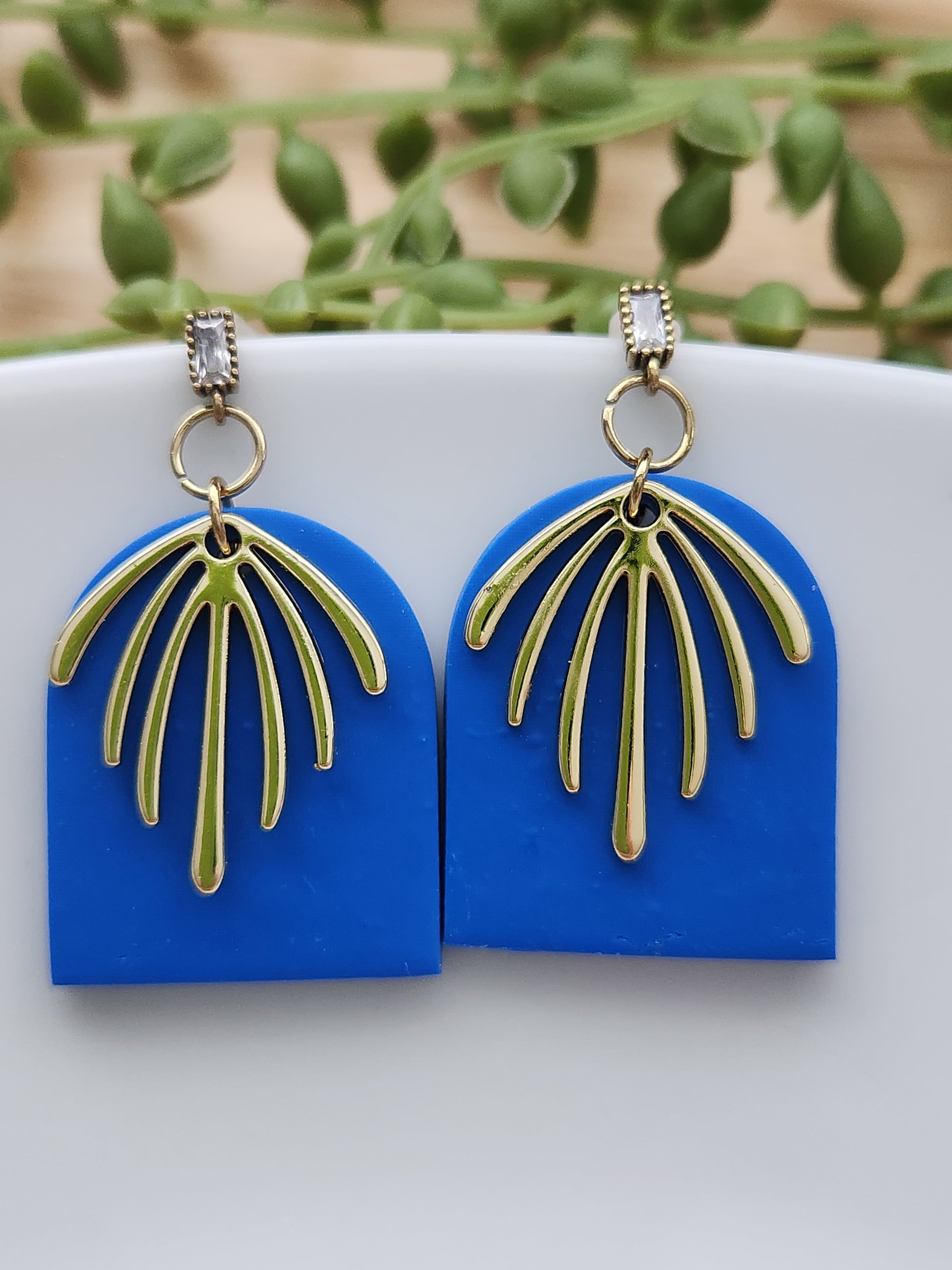 Handmade rich blue polymer clay earrings! This bright blue color is my favorite! These dangle earrings are of a dome shape with a gold-plated charm consisting of 7 lines facing down. A sterling silver needle zircon earring post completes this earring design. They are sure to stand out, lightweight, and approximately 2" long.