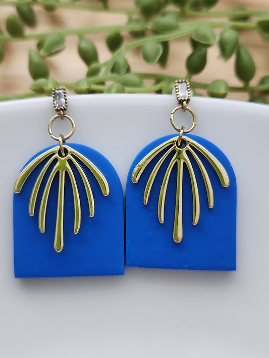 Handmade rich blue polymer clay earrings! This bright blue color is my favorite! These dangle earrings are of a dome shape with a gold-plated charm consisting of 7 lines facing down. A sterling silver needle zircon earring post completes this earring design. They are sure to stand out, lightweight, and approximately 2" long.