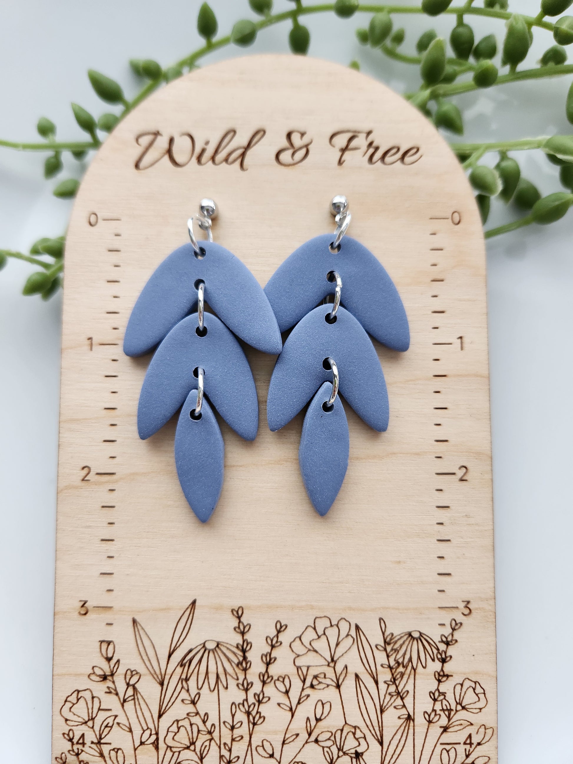 Handmade polymer clay earrings! This beautiful blue clay is perfect for any outfit and any occasion. Clay is cut out into leaf pieces cascading down. A silver-plated circle stud completes this look. These bold earrings are bold, matte, and approximately 2.5" long.&nbsp;