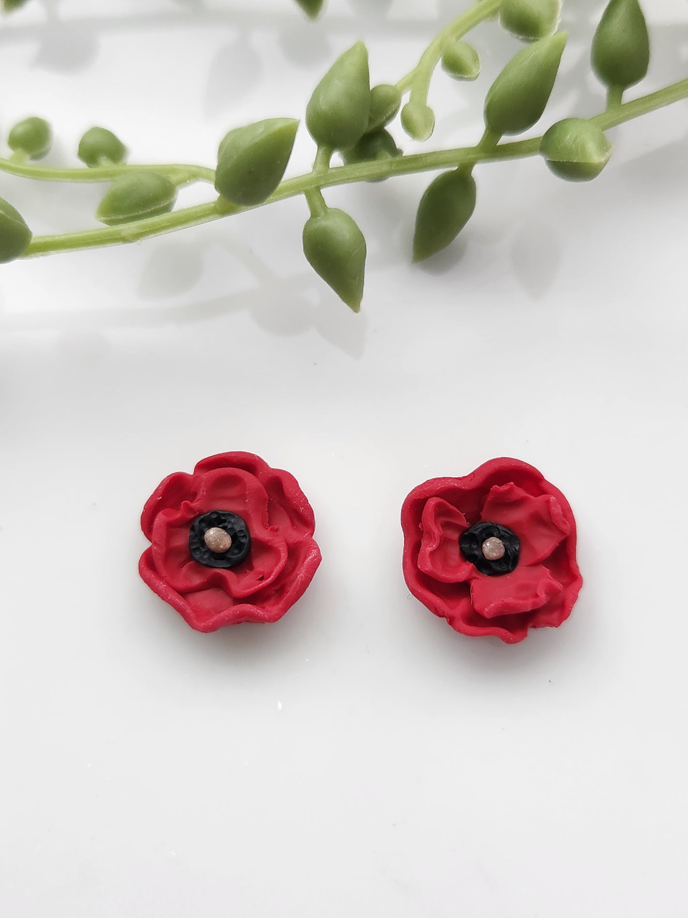 Handmade polymer clay earrings! These beautiful studs are made from red clay in a poppy flower design. They are a unique and perfect touch to any outfit. Lightweight, matte, and approximately .5" long.