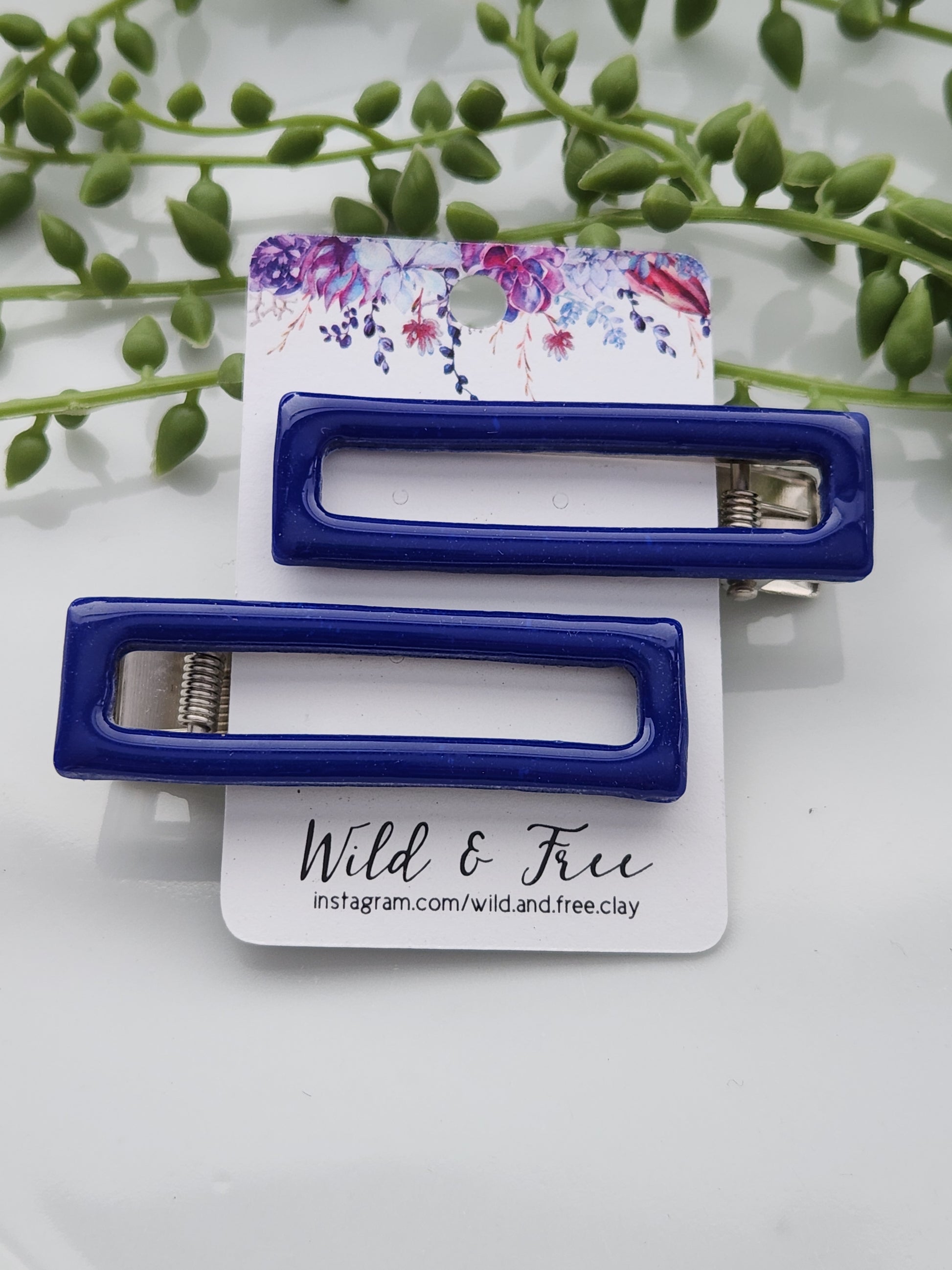 Handmade polymer clay hair clips! Super lightweight clips that bring a pop to any outfit! This beautiful clip is handmade with polymer clay in a navy blue color. The hair clip is a rectangular shape with an open cutout in the middle and is layered with a coat of resin for a shiny look. Approximately 2.5" long.