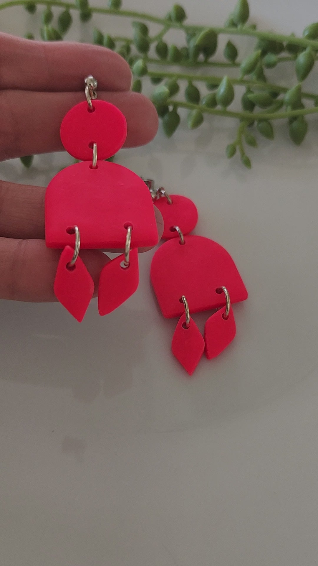 Handmade polymer clay earrings! These stunning hot pink clay earrings are sure to stand out. They consist of a clay circle with a half dome and two small diamond-shaped dangles. A circle ball stud completes this look. They are lightweight and approximately 2.5" long.